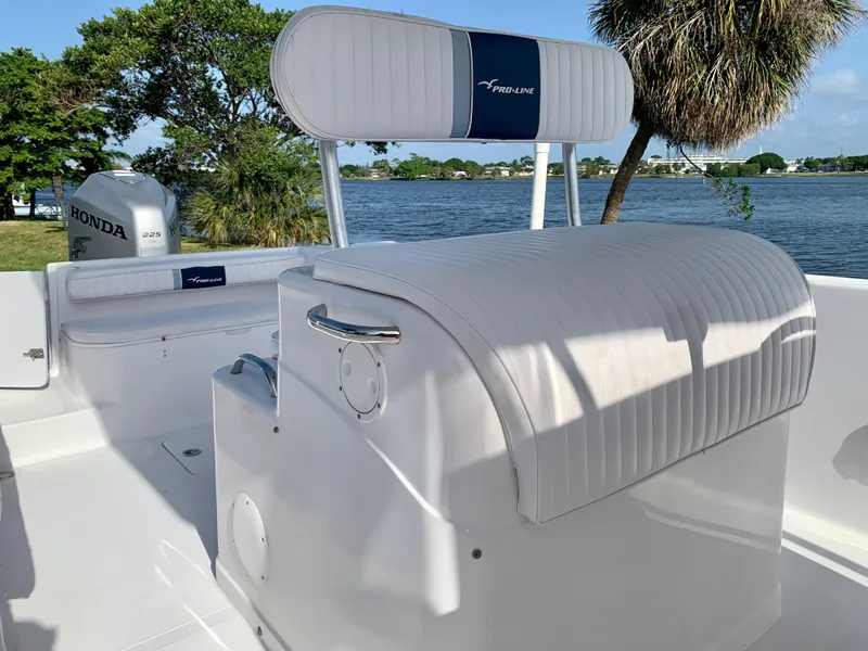 Slide: The Image of 2004 Pro-Line 25 Sport boat interior with white seating and Honda outboard motor. - 24