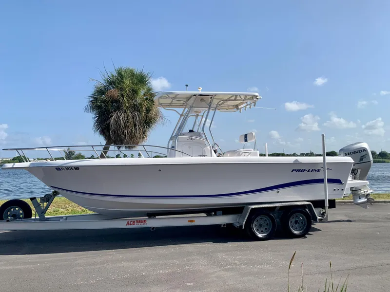 Slide: The Image of 2004 Pro-Line 25 Sport boat on trailer by the water. - 3