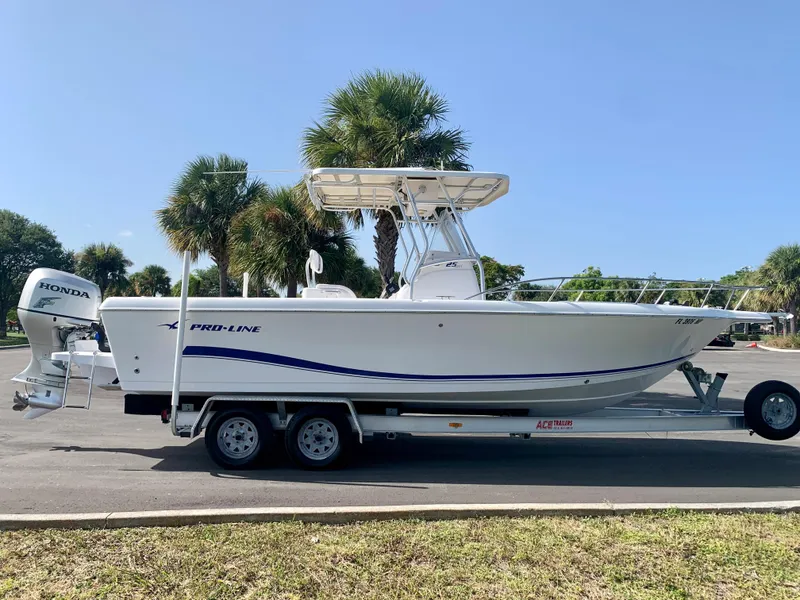 Slide: The Image of 2004 Pro-Line 25 Sport boat on a trailer with Honda outboard motor. - 4
