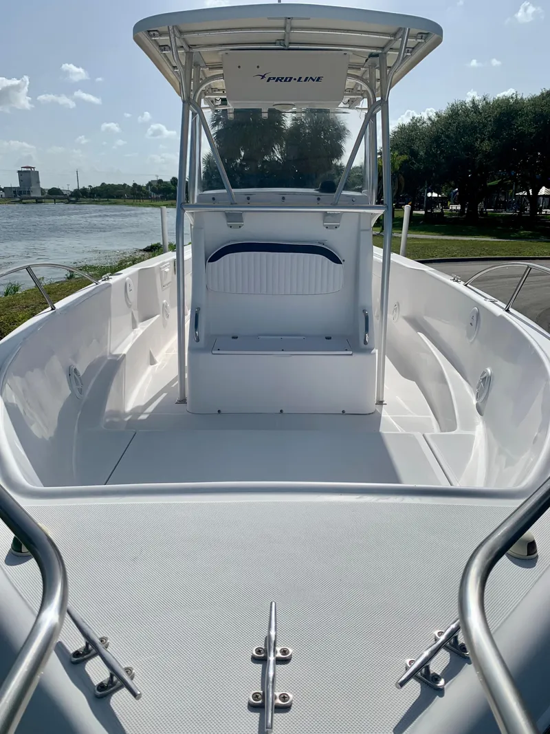 Slide: The Image of 2004 Pro-Line 25 Sport boat with T-top and center console, docked near a lake. - 7