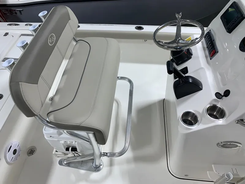 Slide: The Image of 2024 Key West 210 Bay Reef boat helm with cushioned seat and steering wheel. - 9