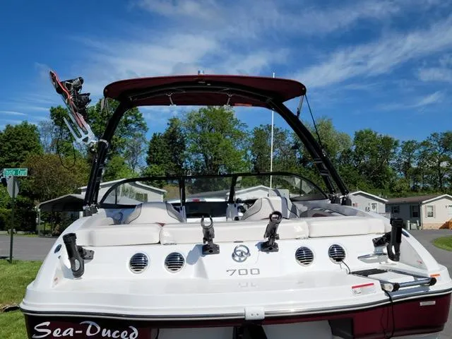 Slide: The Image of 2020 Tahoe 700 boat with wakeboard tower and seating, parked outdoors. - 5