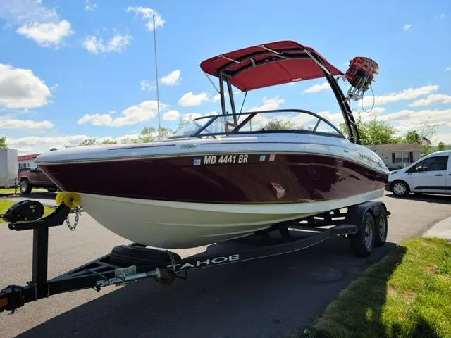 Slide: The Image of 2020 Tahoe 700 boat on trailer with red canopy, parked outdoors. - 6