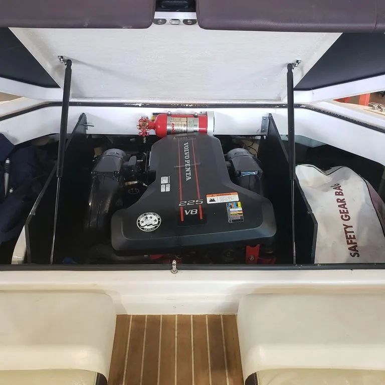 Slide: The Image of 2014 Regal 2100 boat engine compartment with Volvo Penta 225 V6 engine and safety gear bag. - 4