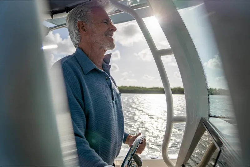 Slide: The Image of Man steering 2023 Boston Whaler 280 Dauntless boat on a sunny day. - 14