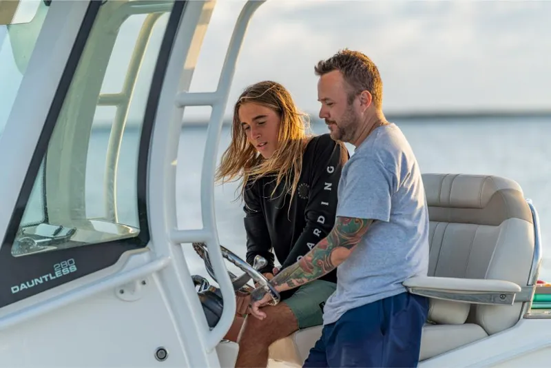 Slide: The Image of 2023 Boston Whaler 280 Dauntless boat with two people at the helm. - 21