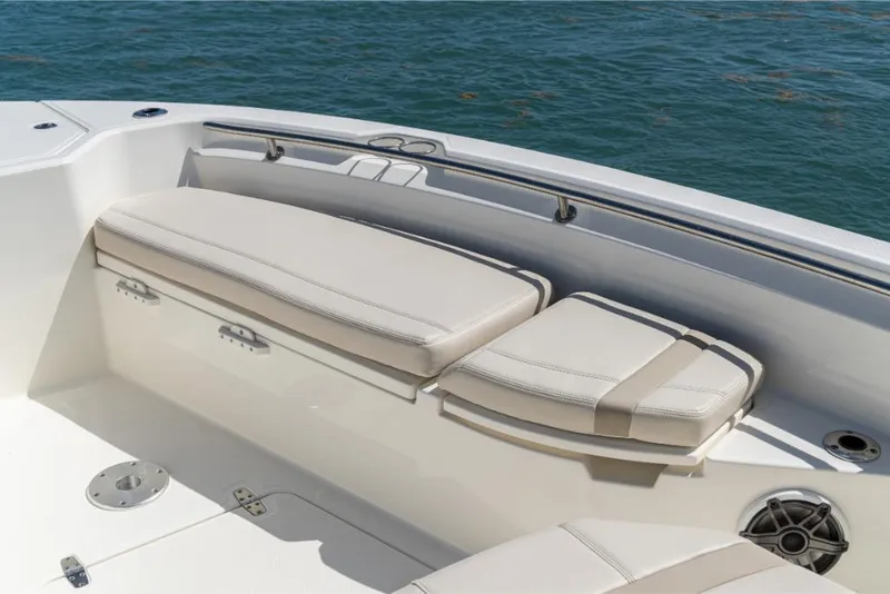 Slide: The Image of 2023 Boston Whaler 280 Dauntless boat seating area with cushioned seats and ocean backdrop. - 36