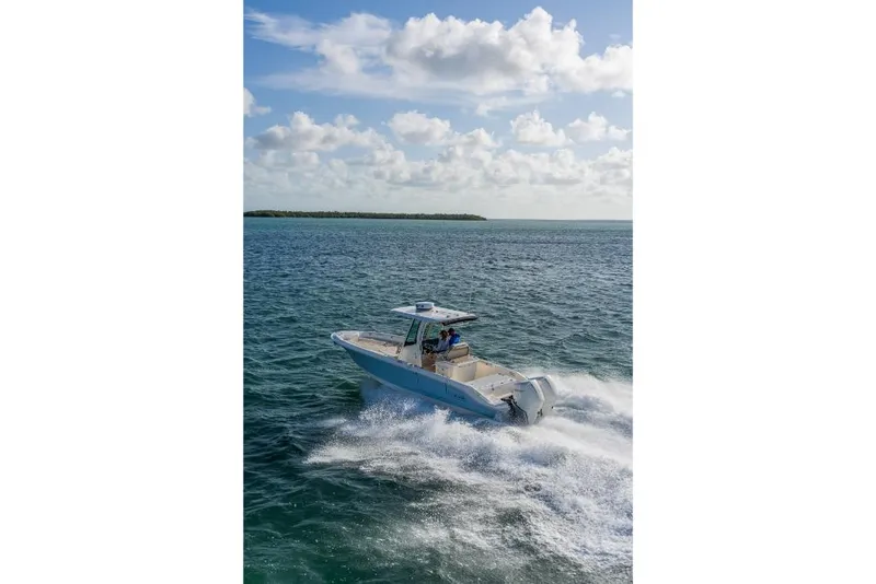 Slide: The Image of 2023 Boston Whaler 280 Dauntless cruising on open water under a partly cloudy sky. - 45