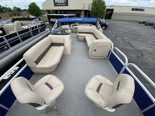 Slide: The Image of 2017 Sun Tracker Fishin' Barge 24 DLX pontoon boat with beige seating and blue accents. - 4