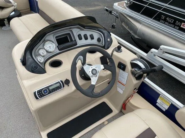 Slide: The Image of 2017 Sun Tracker Fishin' Barge 24 DLX helm with steering wheel and control panel. - 5