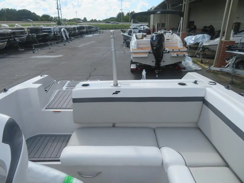 Slide: The Image of 2023 Starcraft SVX OB 231 OB boat interior with rear seating and docked boats in the background. - 14