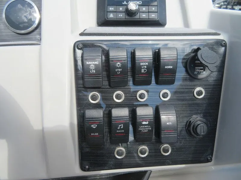 Slide: The Image of Control panel of a 2023 Starcraft SVX OB 231 OB boat with various switches. - 15