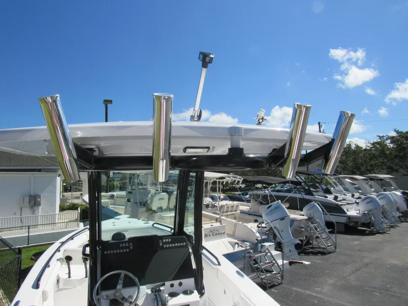 Slide: The Image of 2023 Everglades 253 CC boat with rod holders and console, docked under clear blue sky. - 23