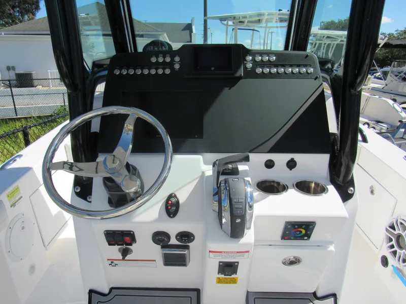 Slide: The Image of 2023 Everglades 253 CC boat helm with steering wheel and control panel. - 4