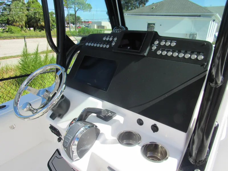 Slide: The Image of 2023 Everglades 253 CC boat dashboard with steering wheel and control panel. - 5