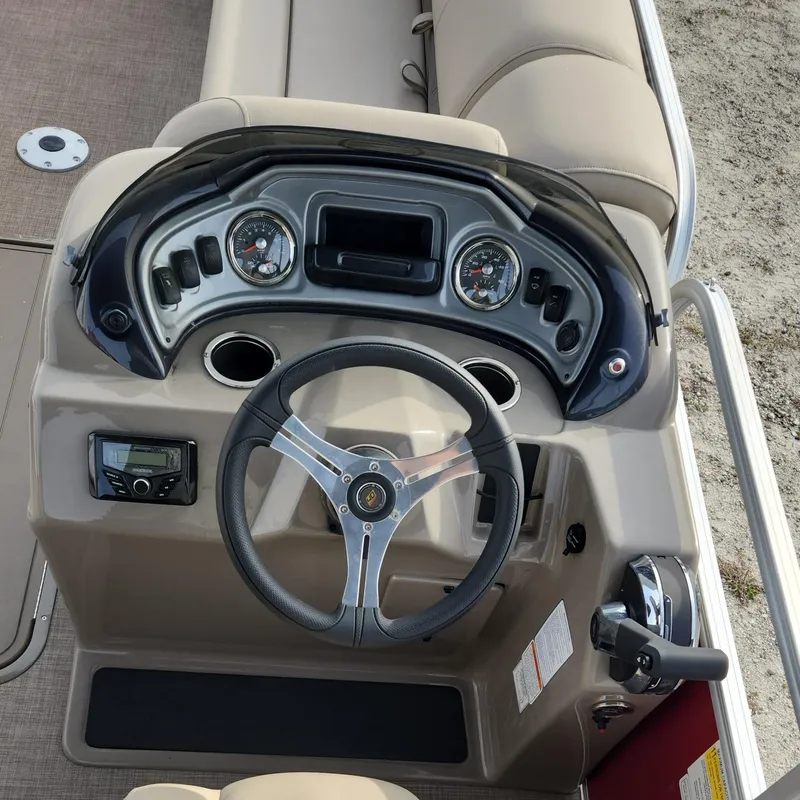 Slide: The Image of 2023 Sun Tracker Party Barge 22 XP3 steering console with gauges and controls. - 2
