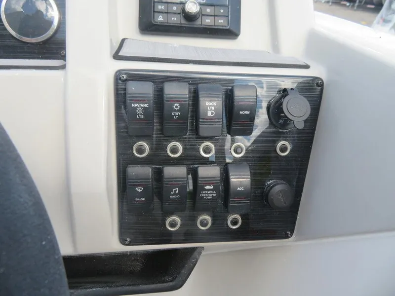 Slide: The Image of Control panel of a 2023 Starcraft SVX OB 191 OB boat with various switches. - 11