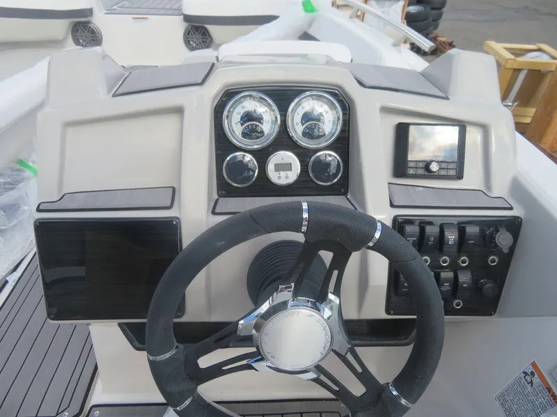 Slide: The Image of 2023 Starcraft SVX OB 191 OB boat dashboard with steering wheel and control panel. - 13