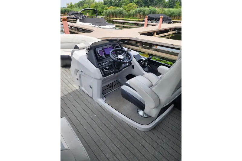 Slide: The Image of 2023 Viaggio Diamante 23U boat helm with modern controls and comfortable seating at dock. - 31