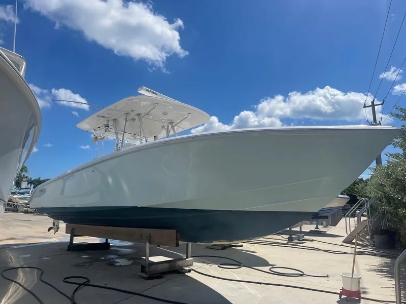 The Image of 2004 Venture 34 Open boat on a sunny day, displayed on a stand. - 0