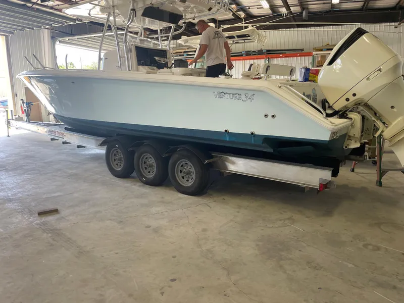 Slide: The Image of 2004 Venture 34 Open boat on trailer in a garage setting. - 2