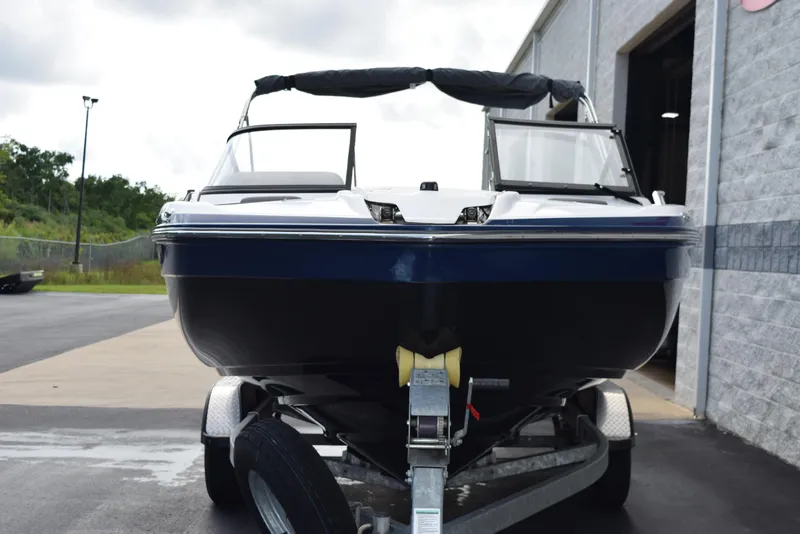 Slide: The Image of 2017 Yamaha Boats 212 Limited on trailer outside a garage. - 3