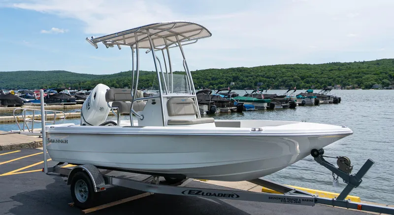 Slide: The Image of 2023 Savannah 190 IS boat on trailer by the lake. - 0