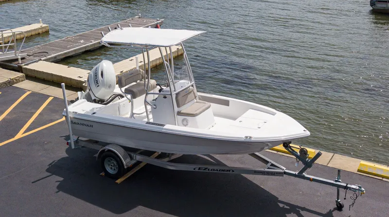 Slide: The Image of 2023 Savannah 190 IS boat on trailer by the water. - 1