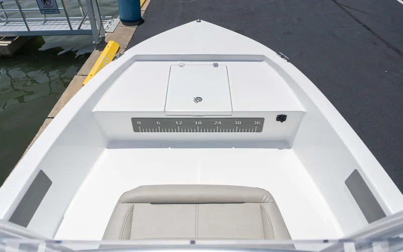 Slide: The Image of 2023 Savannah 190 IS boat interior at dock, featuring a cushioned seat and storage compartment. - 11