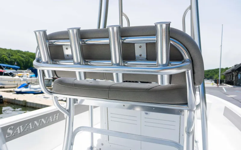 Slide: The Image of 2023 Savannah 190 IS boat with rod holders and cushioned seating at the dock. - 6