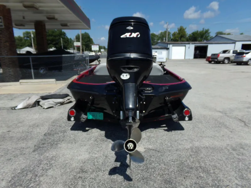Slide: The Image of 2000 Ranger 518SVX Comanche boat with outboard motor, parked in a lot under clear skies. - 12