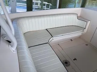Slide: The Image of 2002 Intrepid 322 boat with white cushioned seating area. - 16