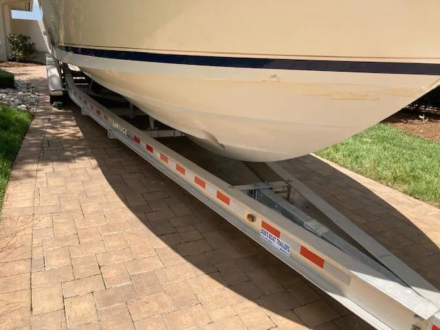 Slide: The Image of 2002 Intrepid 322 boat on a trailer in a driveway. - 2