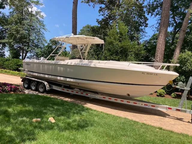 Slide: The Image of 2002 Intrepid 322 boat on a trailer in a lush, green yard. - 3