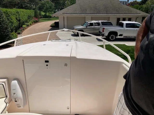 Slide: The Image of 2002 Intrepid 322 boat parked in a driveway with trucks in the background. - 8