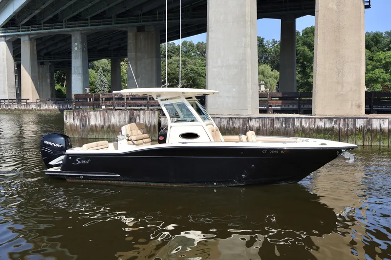 Slide: The Image of 2016 Scout 255 LXF boat on water near a bridge. - 0