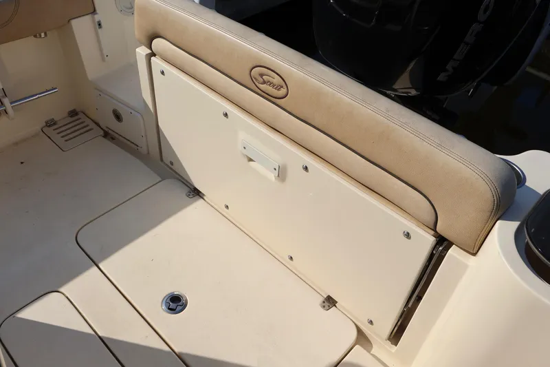 Slide: The Image of 2016 Scout 255 LXF boat interior with cushioned seating and storage compartment. - 13