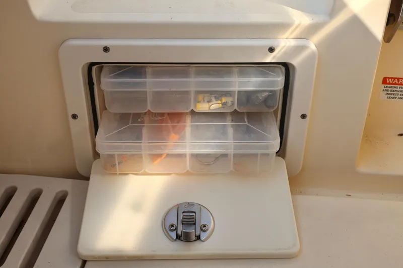 Slide: The Image of Storage compartment with tackle boxes on a 2016 Scout 255 LXF boat. - 18
