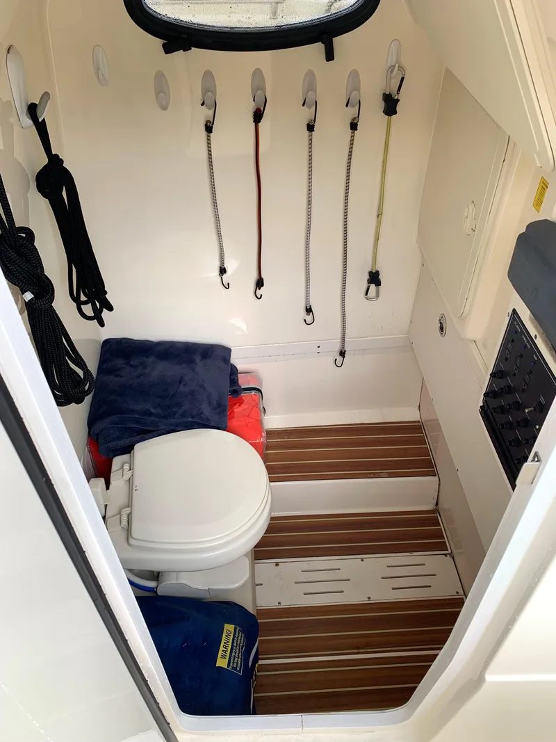 Slide: The Image of 2016 Scout 255 LXF boat interior with toilet and storage. - 19