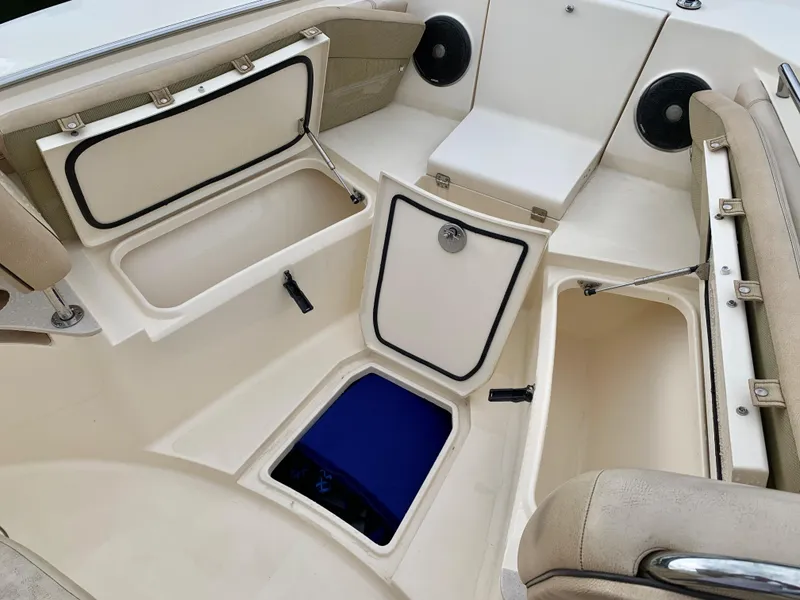 Slide: The Image of 2016 Scout 255 LXF boat interior with open storage compartments and seating. - 24