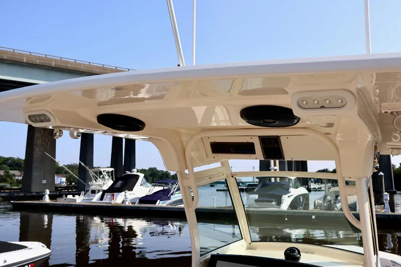 Slide: The Image of 2016 Scout 255 LXF boat with speakers and marina view. - 28