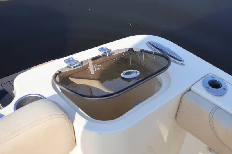 Slide: The Image of 2016 Scout 255 LXF boat with open storage compartment and seating. - 31