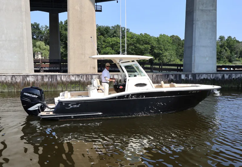 Slide: The Image of 2016 Scout 255 LXF boat cruising under a bridge on a sunny day. - 35