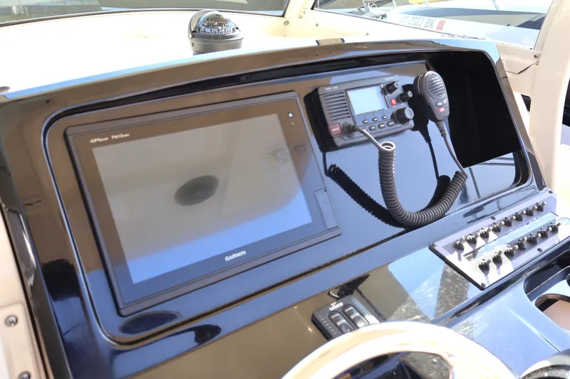 Slide: The Image of 2016 Scout 255 LXF boat dashboard with Garmin display and radio controls. - 6
