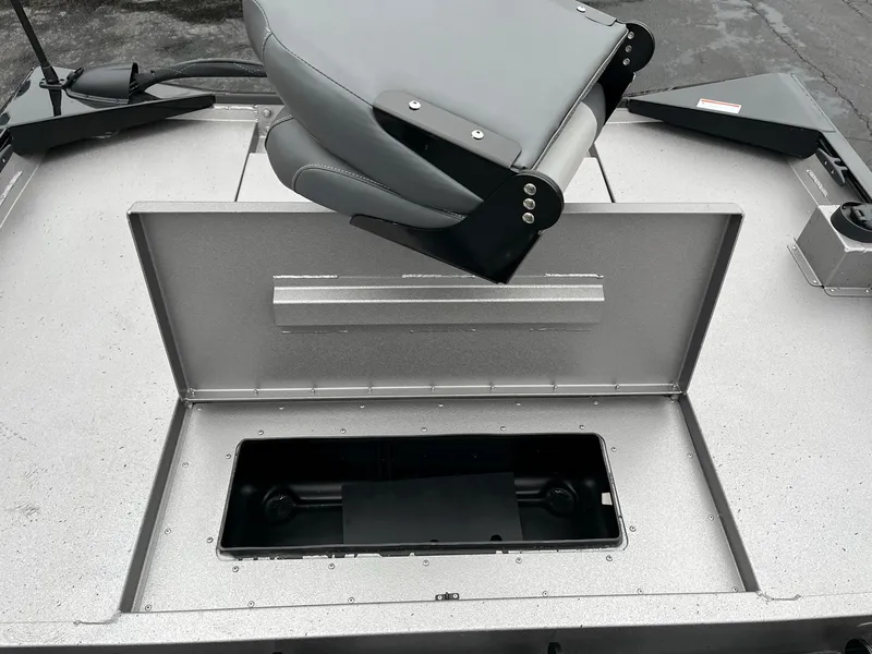 Slide: The Image of 2024 Lowe Legacy boat with open storage compartment and gray seat. - 11