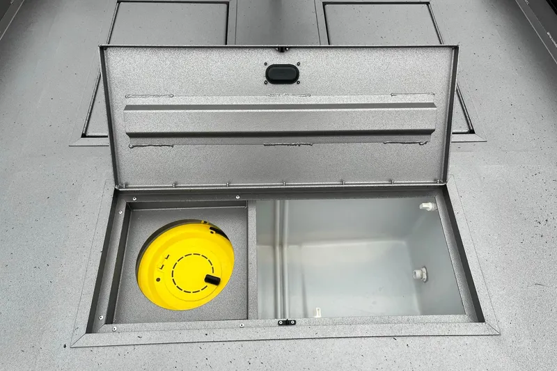 Slide: The Image of 2024 Lowe Legacy boat storage compartment with yellow container. - 12