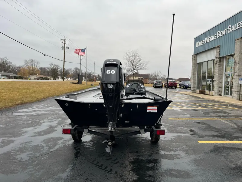 Slide: The Image of 2024 Lowe Legacy boat at dealership, rear view with 60 HP motor. - 2