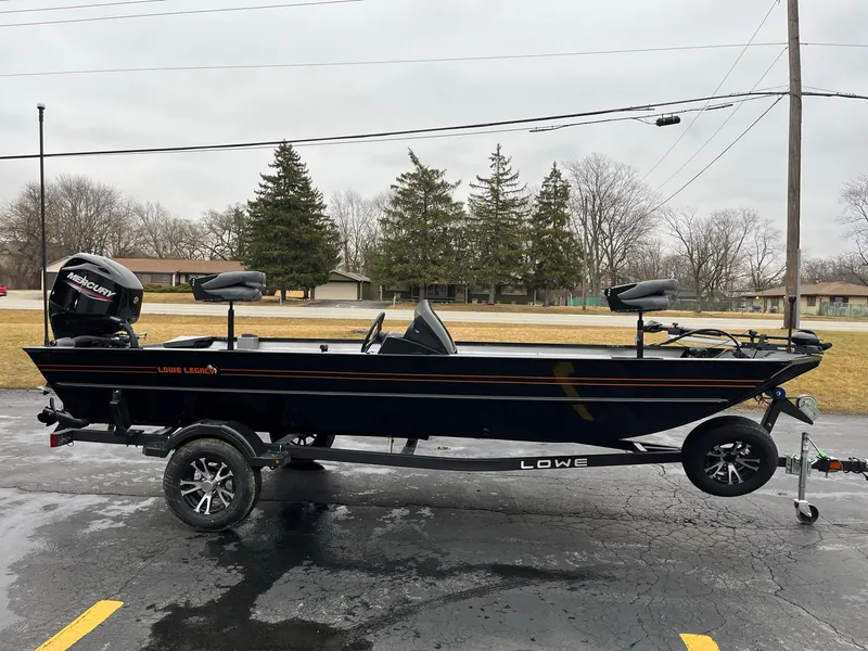 Slide: The Image of 2024 Lowe Legacy boat on trailer, parked outdoors on a cloudy day. - 3