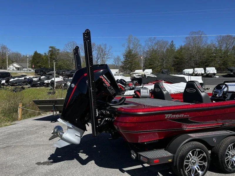 Slide: The Image of 2022 Triton 21 XrT boat with powerful outboard motor in a parking lot. - 6