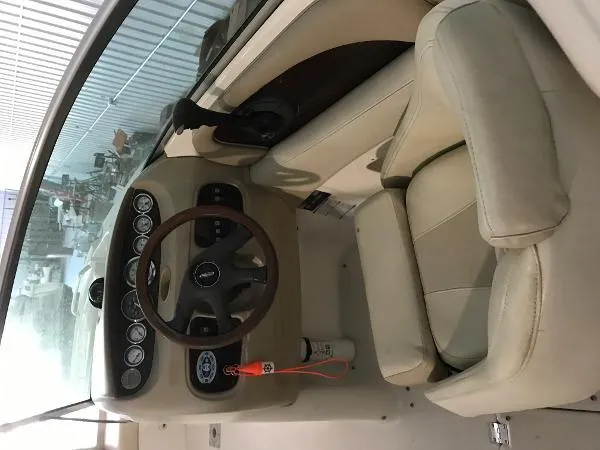 Slide: The Image of 2004 Chaparral 274 SUNESTA boat cockpit with steering wheel and beige seating. - 4